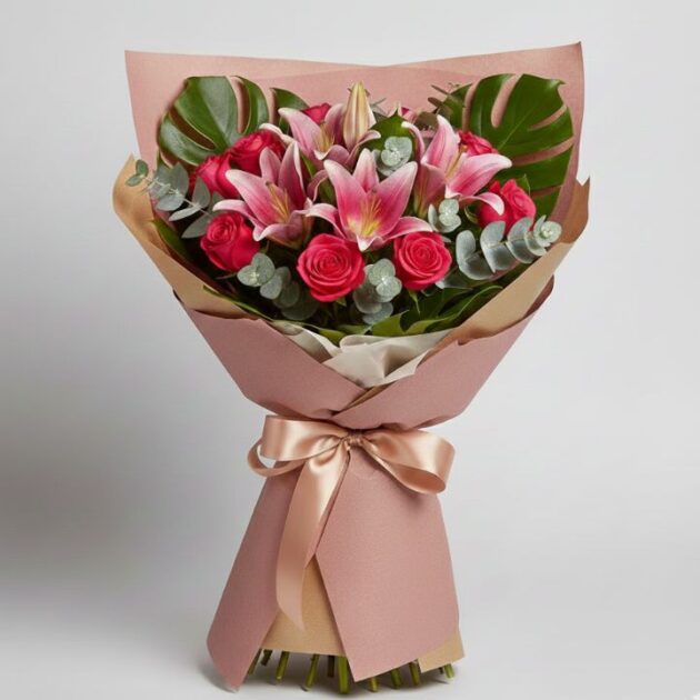 A luxury Pink Rose & Oriental Lily Bouquet wrapped in premium paper with monstera leaves and eucalyptus.