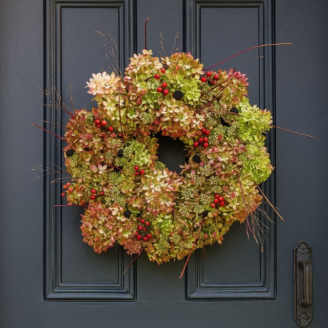 Blog 15 A beautifully natural luxury Christmas wreath for a front door, made from dried hydrangea flowers, red berries, and delicate twigs, hanging on a dark gray door. Luxury Christmas Wreaths For Front Door for sales